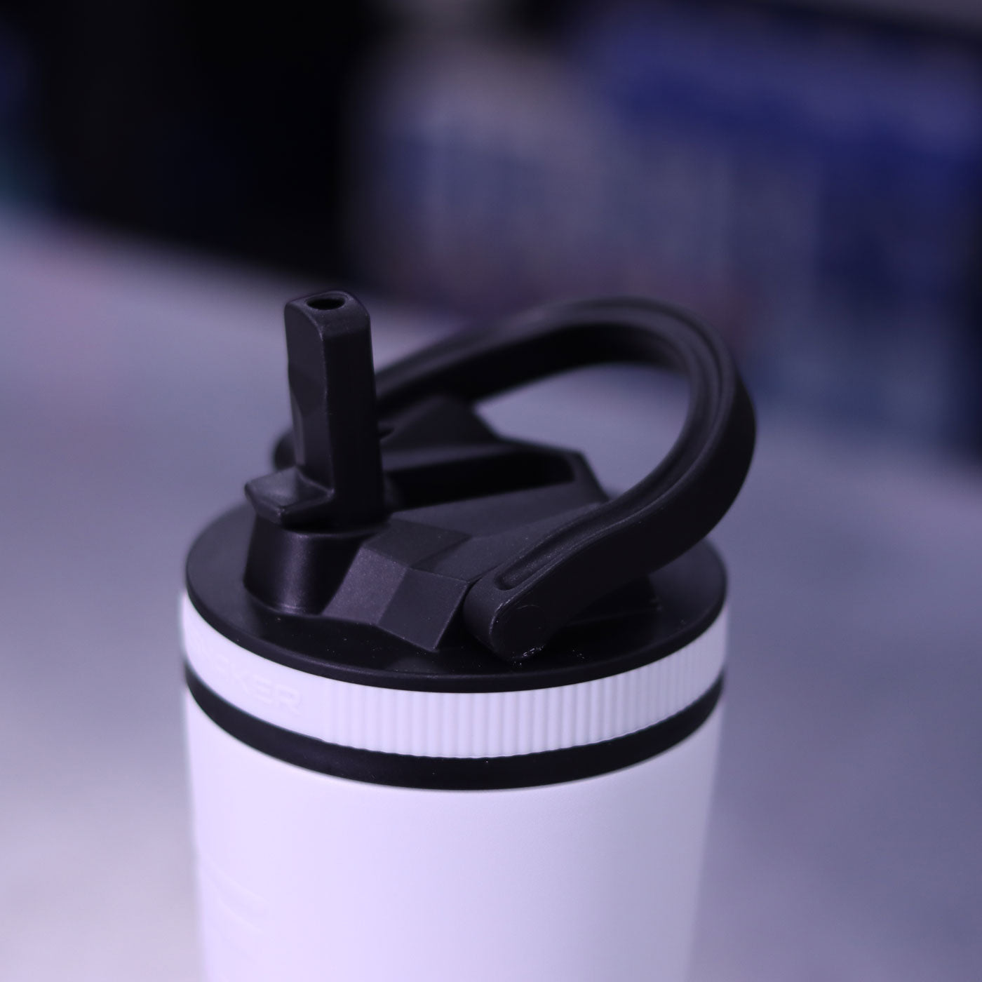 An image showing a close-up view of the Sport Bottle Lid with the Flip Up Sport Straw up and a carry handle on built into the lid.
