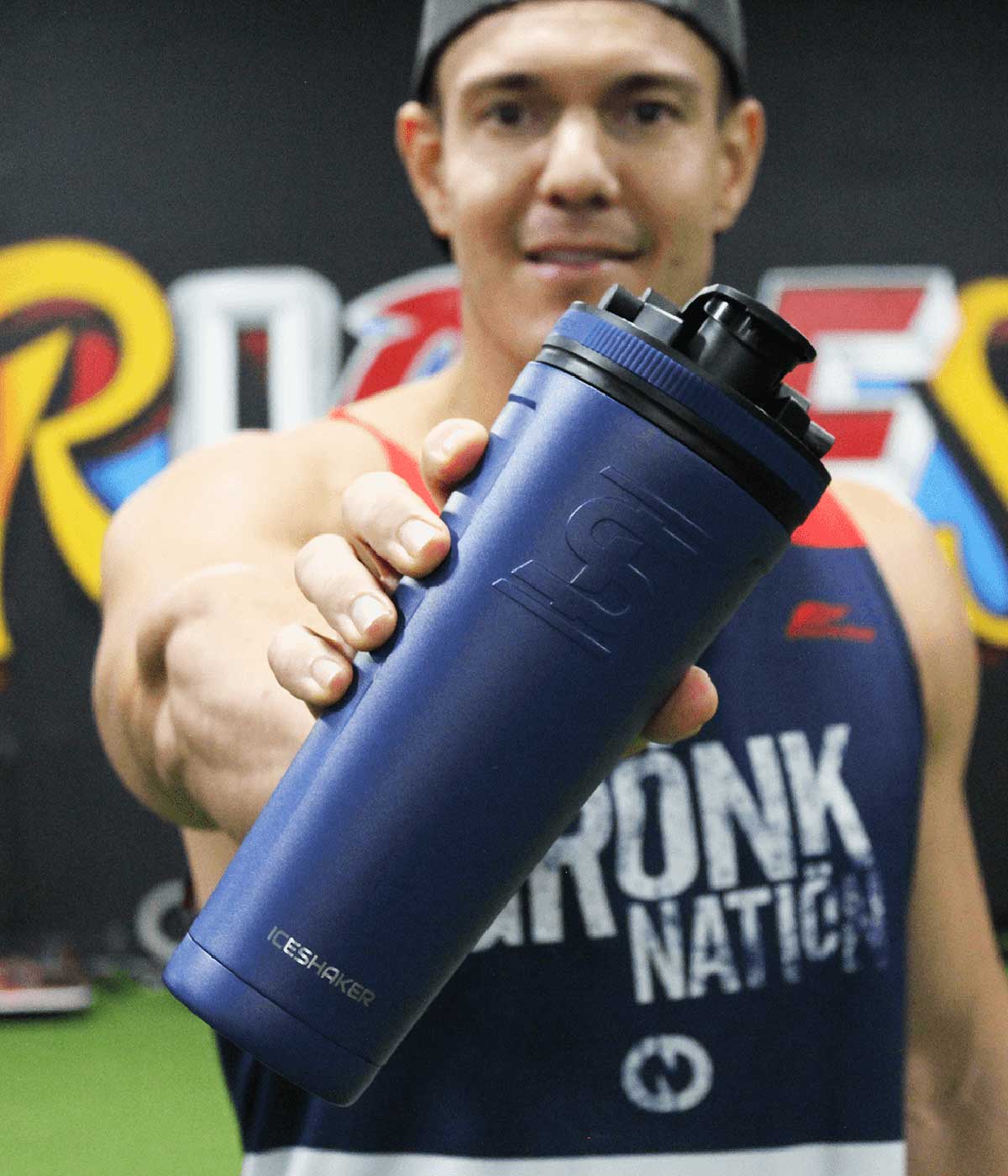 Ice Shaker CEO, Chris Gronkowski holds out the navy-colored 36oz Ice Shaker in front of him.