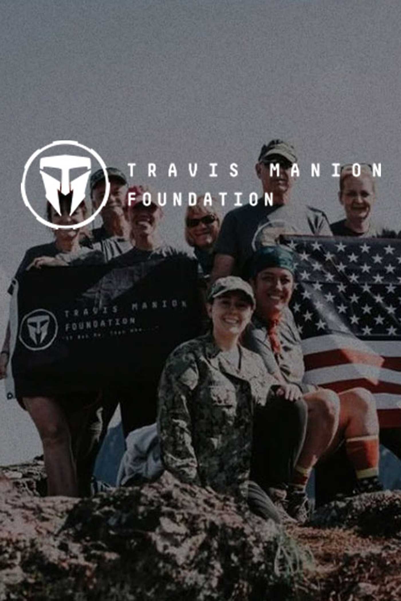 A group of excited people stand atop a mountain holding the United States of America Flag and the Travis Manion Foundation Flag. The Travis Manion Foundation logo overlays on top of the image.