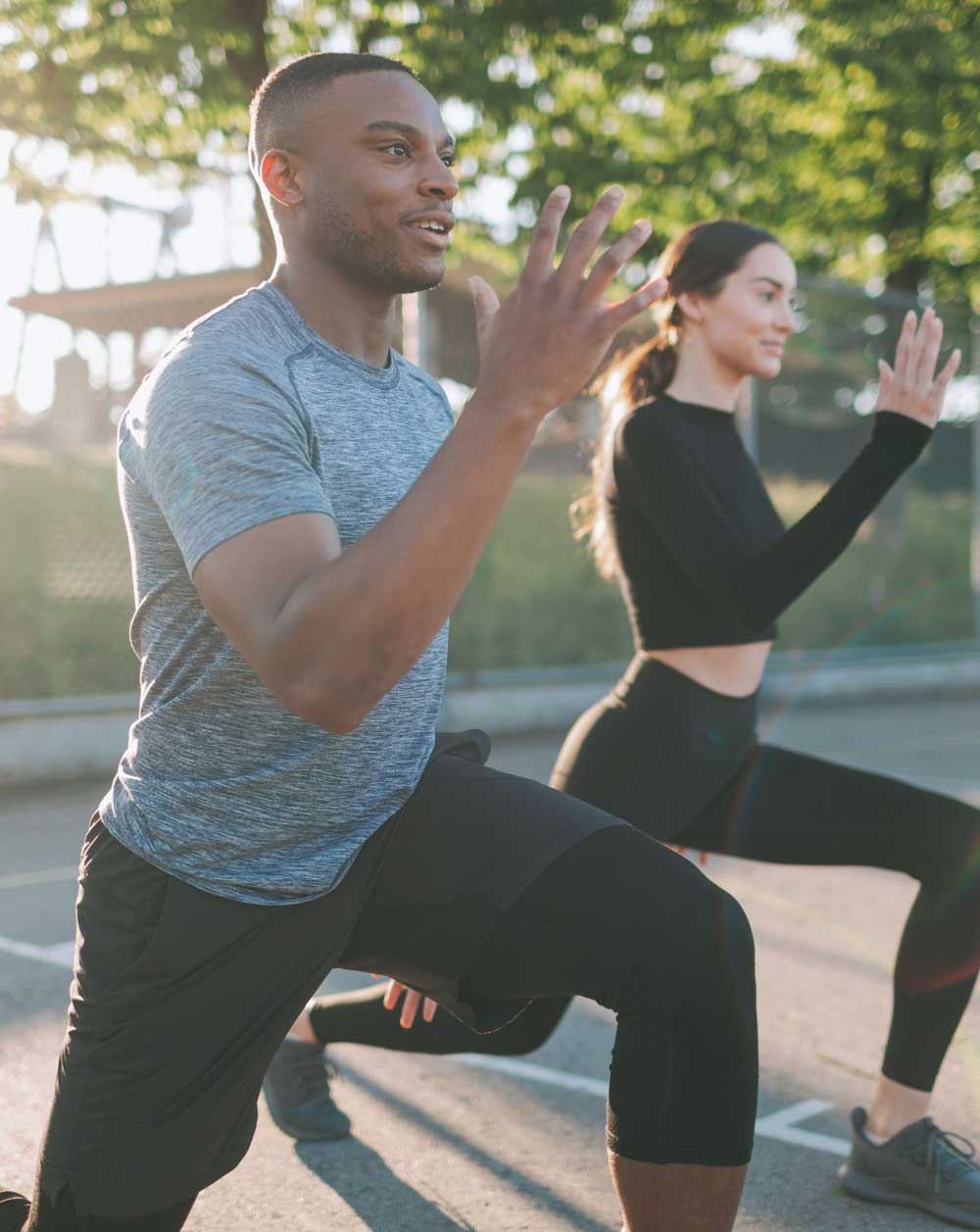 an image of a man and a woman working out outdoors