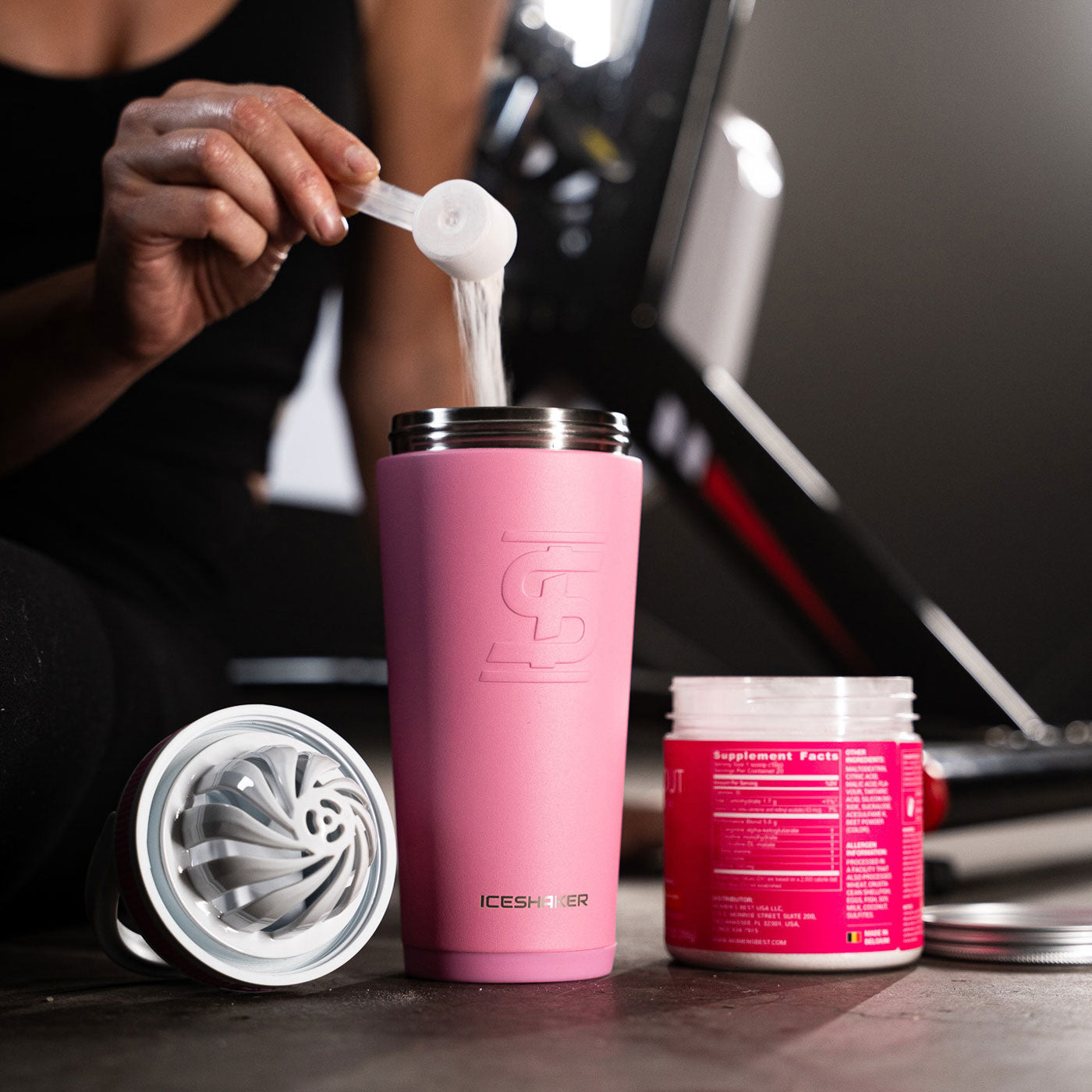 a pink Ice Shaker Shaker Bottle with protein powder being added to it.