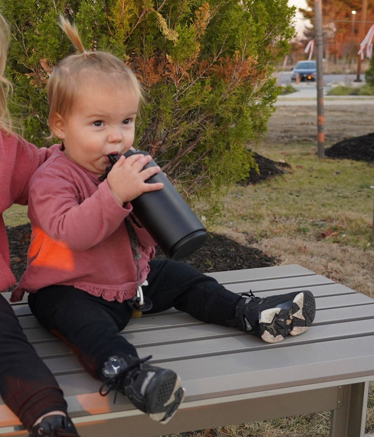 This image shows a toddler-aged girl taking a drink from a black 14oz Sport Bottle.