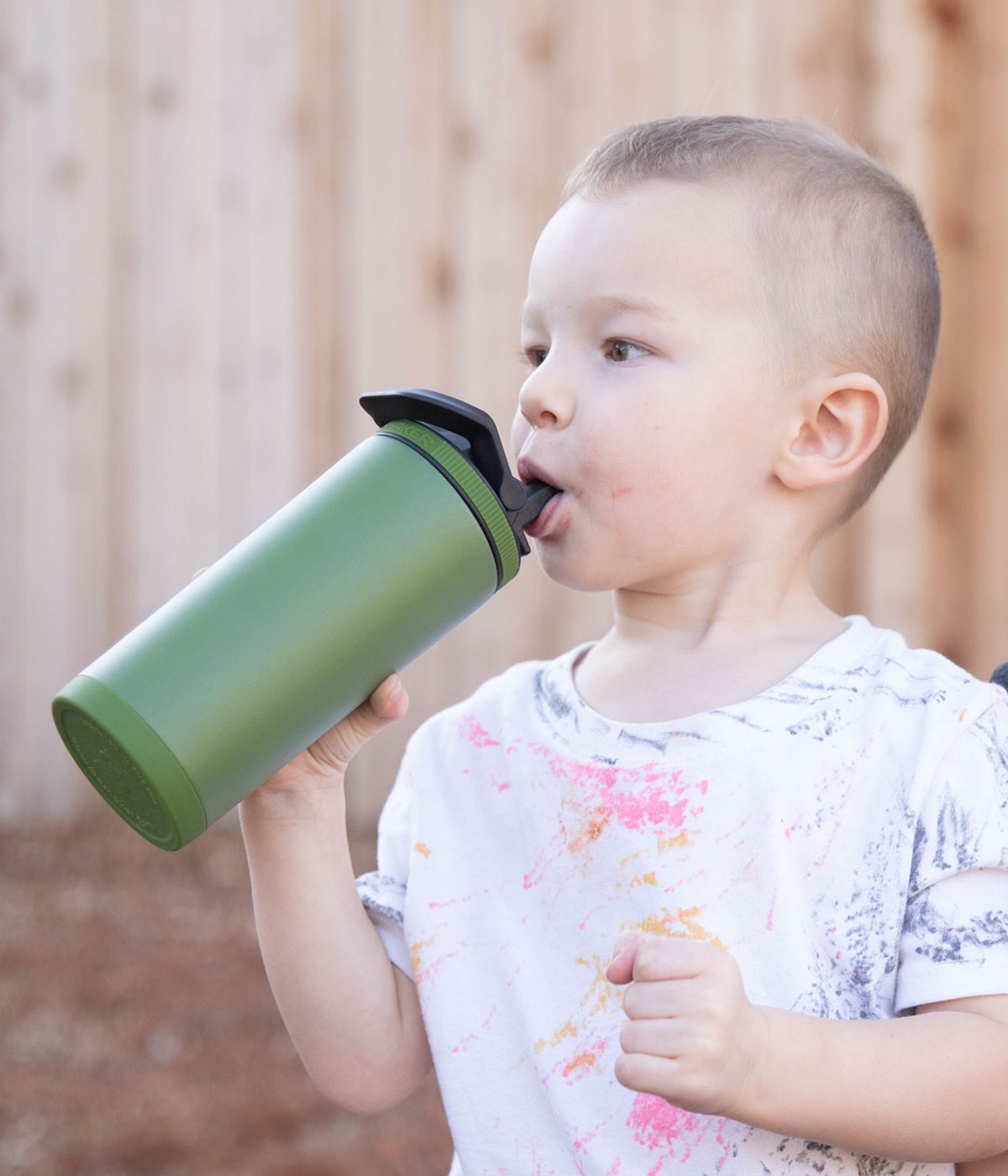 The image shows a little, toddler-aged boy taking a drink from a 14oz Sport Bottle.