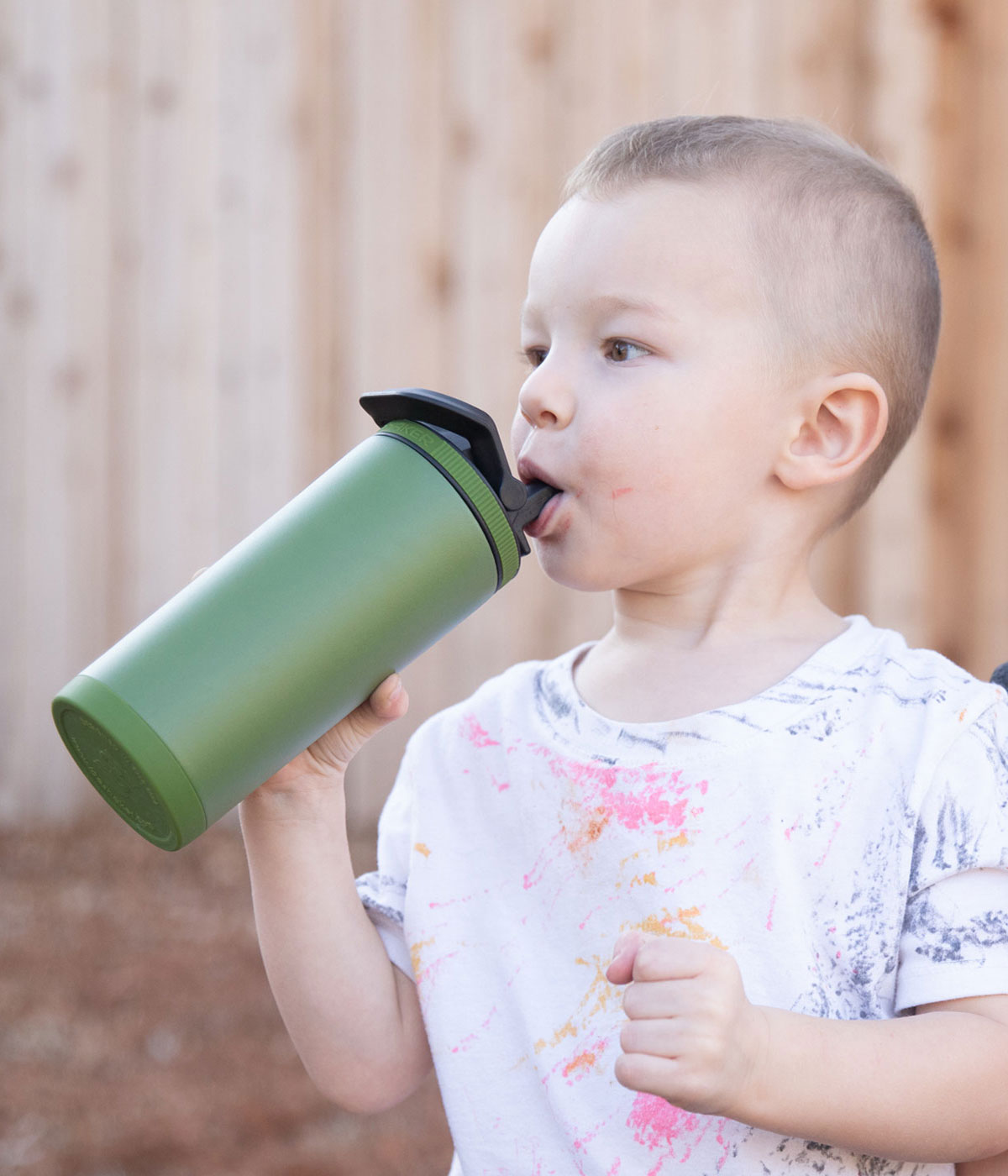The image shows a little, toddler-aged boy taking a drink from a 14oz Sport Bottle.