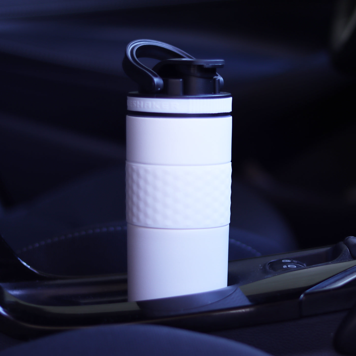 An image of a white 20oz Skinny Shaker fitting easily in the cup holder of a car.