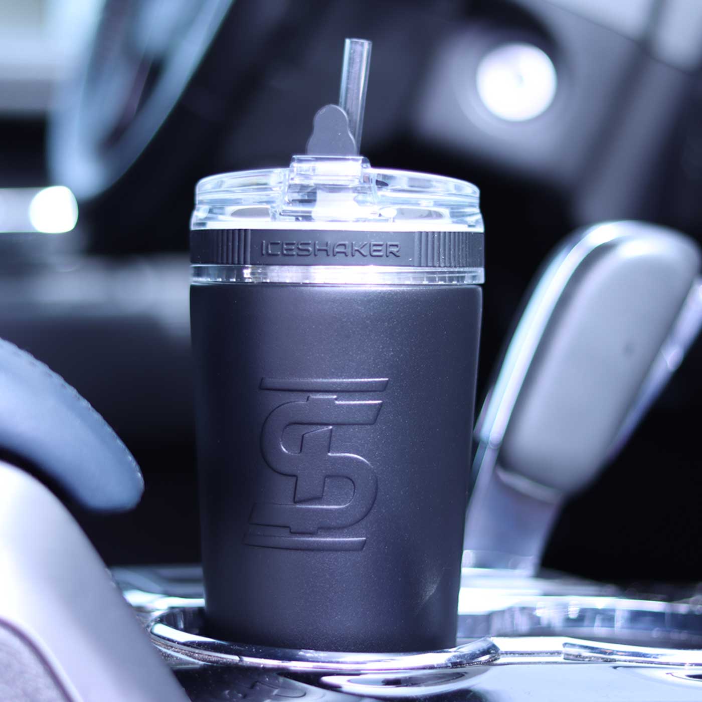 A Black 26oz Flex Bottle with the straw inserted sits easily in a cup holder in a car.