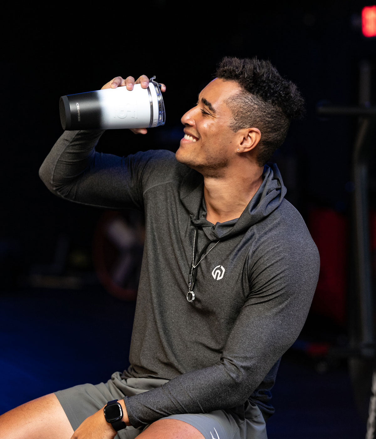 This image shows a young, athletic man taking a drink from a White Black Ombre-colored 26oz Flex Bottle.