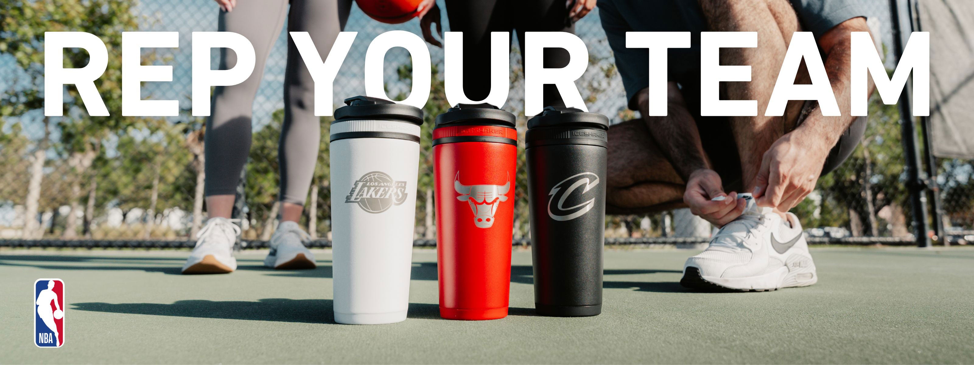 Three NBA engraved Shaker Bottles by Ice Shaker on a court with people in the background and text 'REP YOUR TEAM'